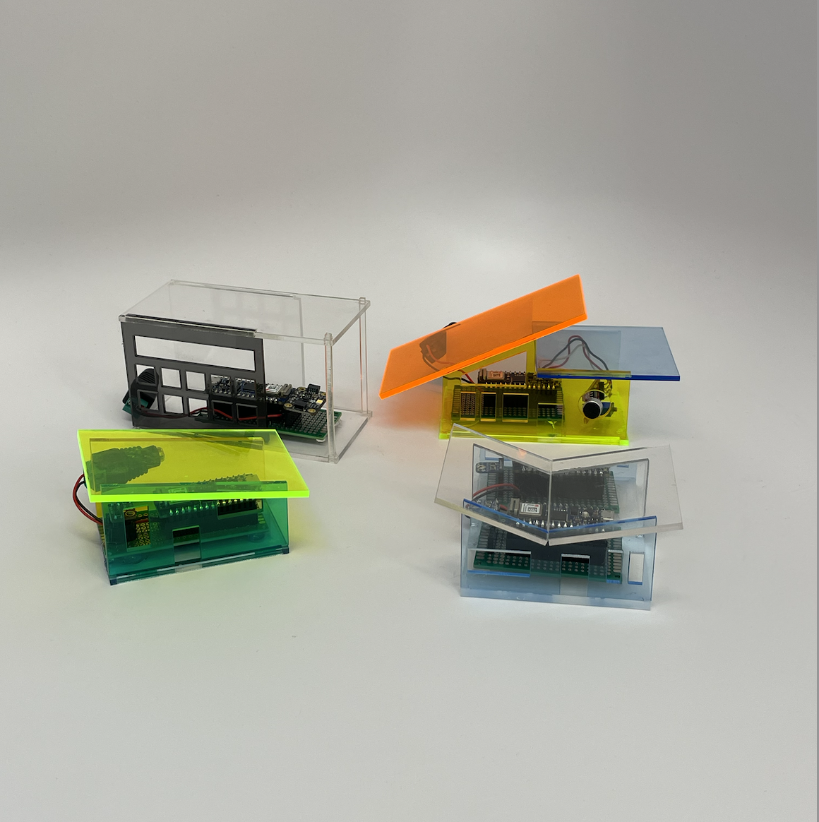 small houses made of acrylic housing arduinos and environmental sensors.
